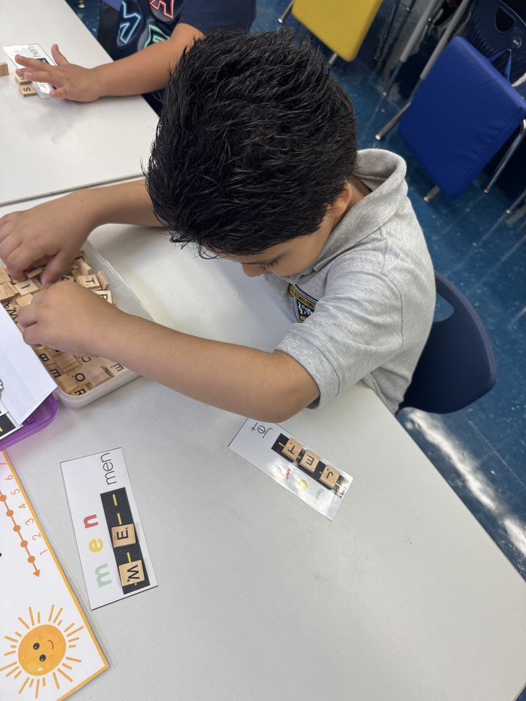 Child using Scrabble tiles to spell a word