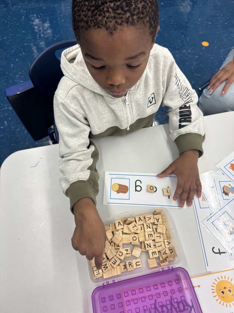 Child using Scrabble tiles to spell a word