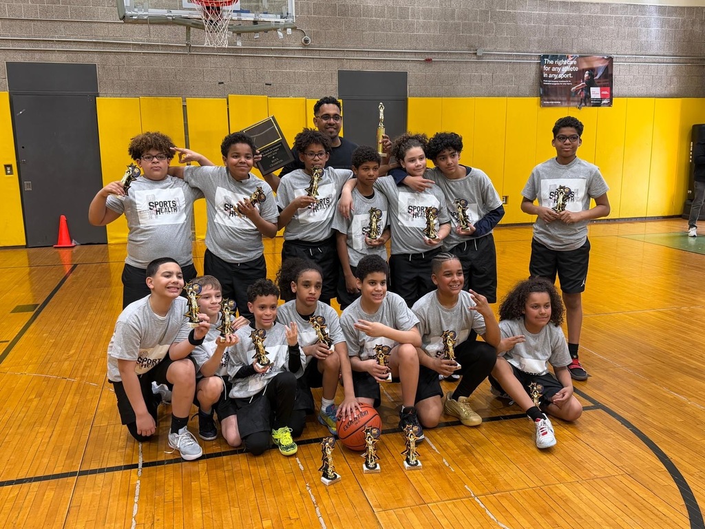 PS 115 boys basketball team posing with their championship trophies.
