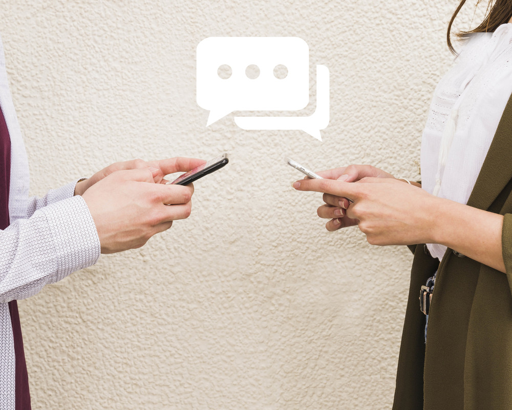 Man and woman exchanging messages on mobile phone