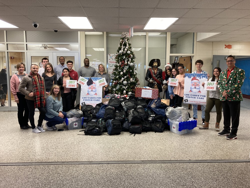 Lumberton High School students, staff and Robeson County DSS officials stand Tuesday with donations for foster care children and families