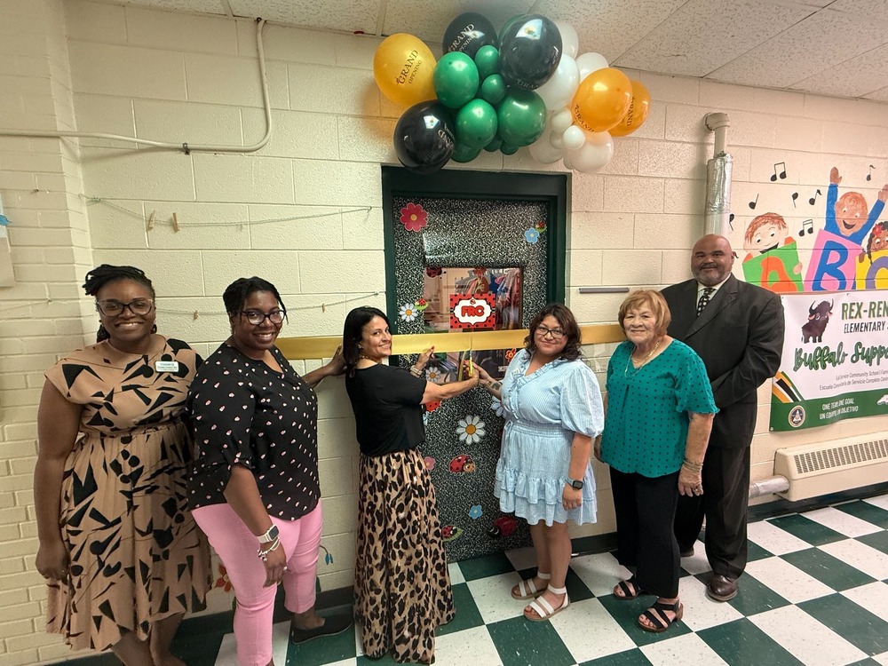 PSRC staff stand infront of ribbon, doorway and colorful balloons ahead of ribbon cutting