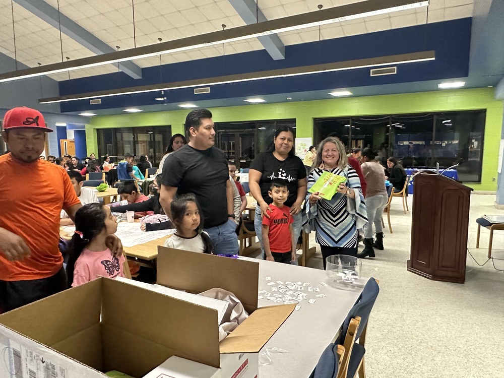 Sandra Lopez stands with multilingual learners and their families during a recent Family and Community Engagement event
