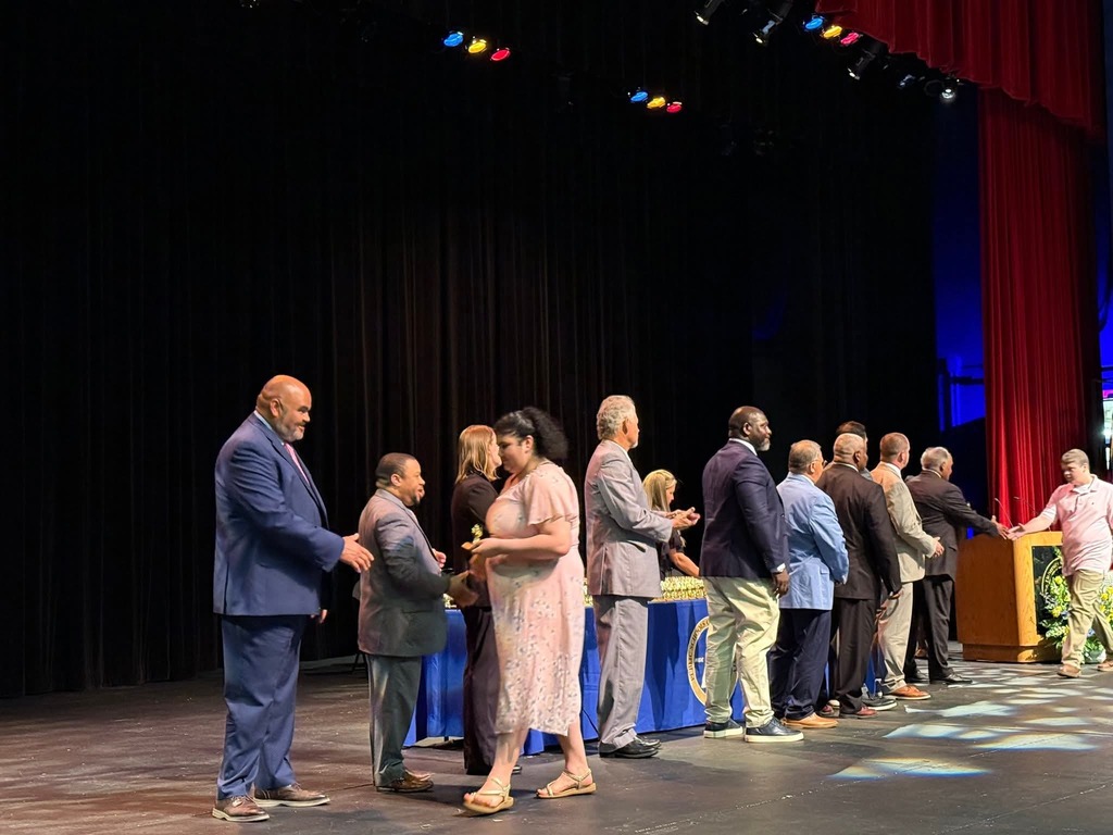Casyn and Tiffany shaking hands with board members