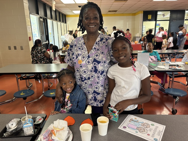 A family smiling at the school breakfast