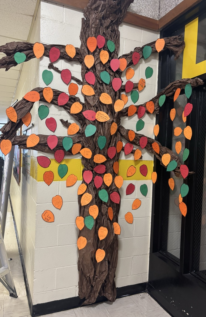 A paper tree with fall colored leaves and messages from family