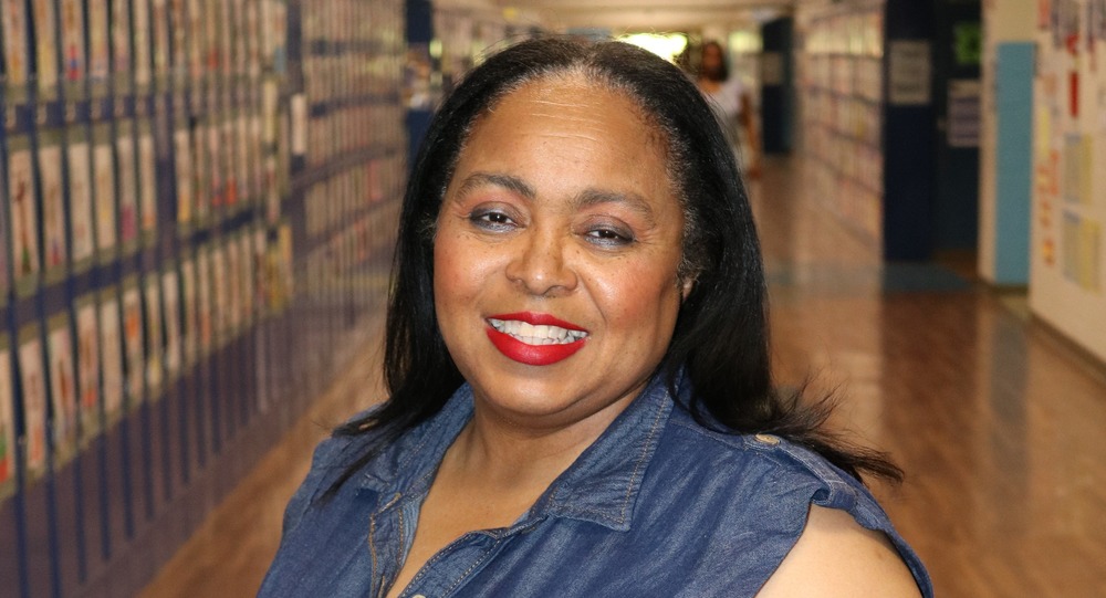 Lillian Hemphill smiling in a Sylvan Hills Middle School hallway. Lockers are visible to her left.