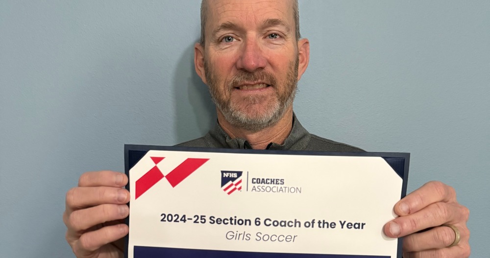 Eskola holds coach of the year award