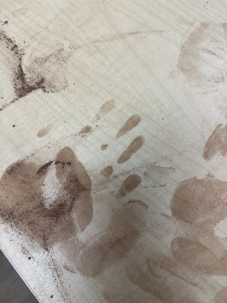 Image of a handprint on the desk that was used to learn about the process of collecting fingerprints.