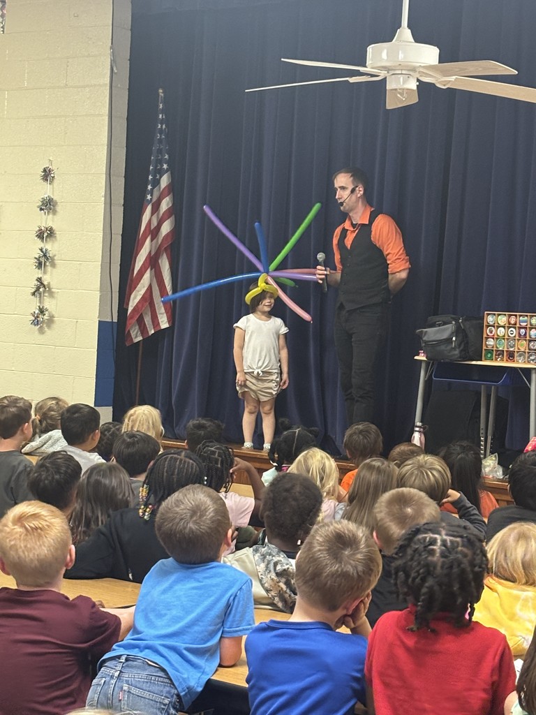 Performer Frank on stage with a first grade student who was chosen from the audience to be part of the show.  