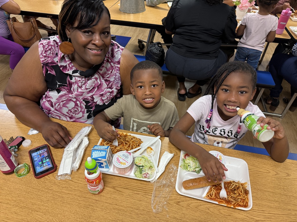 Image of a first grade student and a pre-k student with their grandmother.