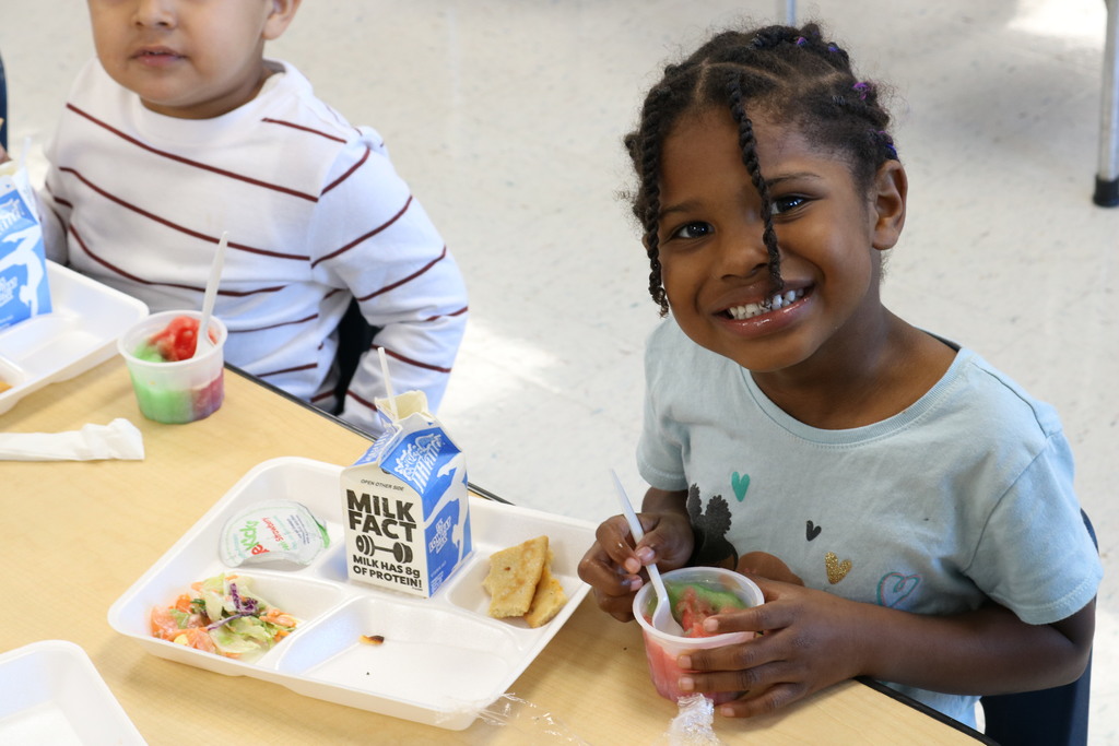 Happy preschooler eating lunch at Harris Elementary