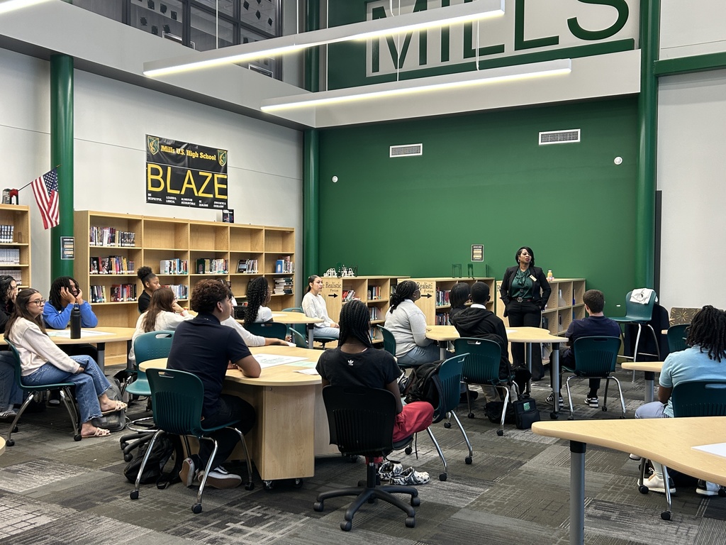 Students in library listening to speaker