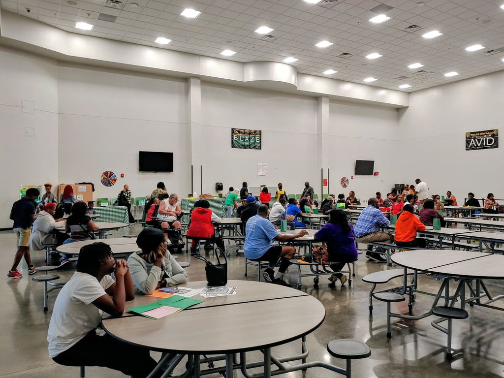 Multiple families sitting in meeting at school cafeteria