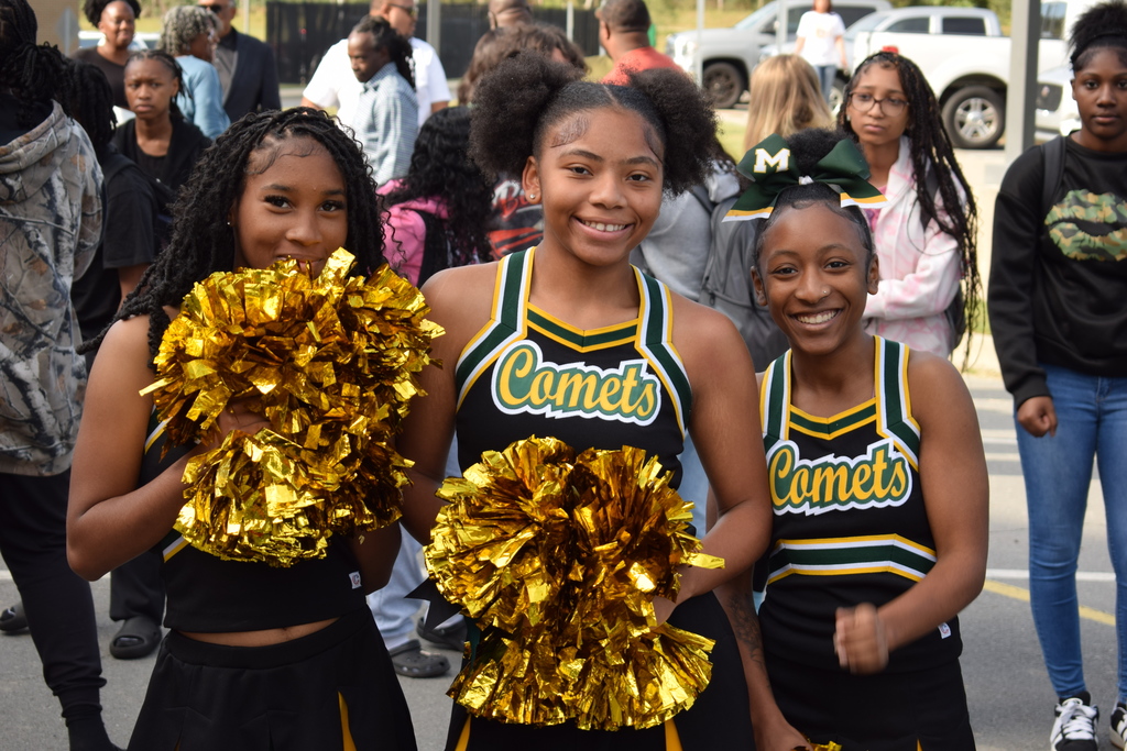 Three Mills University Studies High School cheerleaders smiling directly at the camera