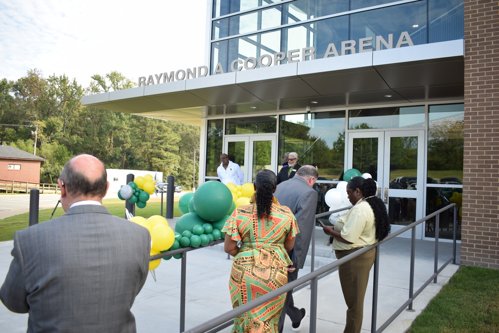 Exterior of the Raymond A. Cooper Arena with its name revealed. People are beginning to walk in.
