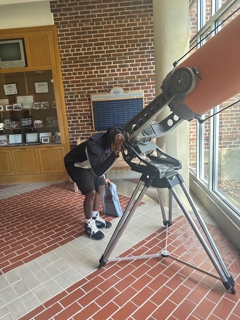 Student checking out telescope