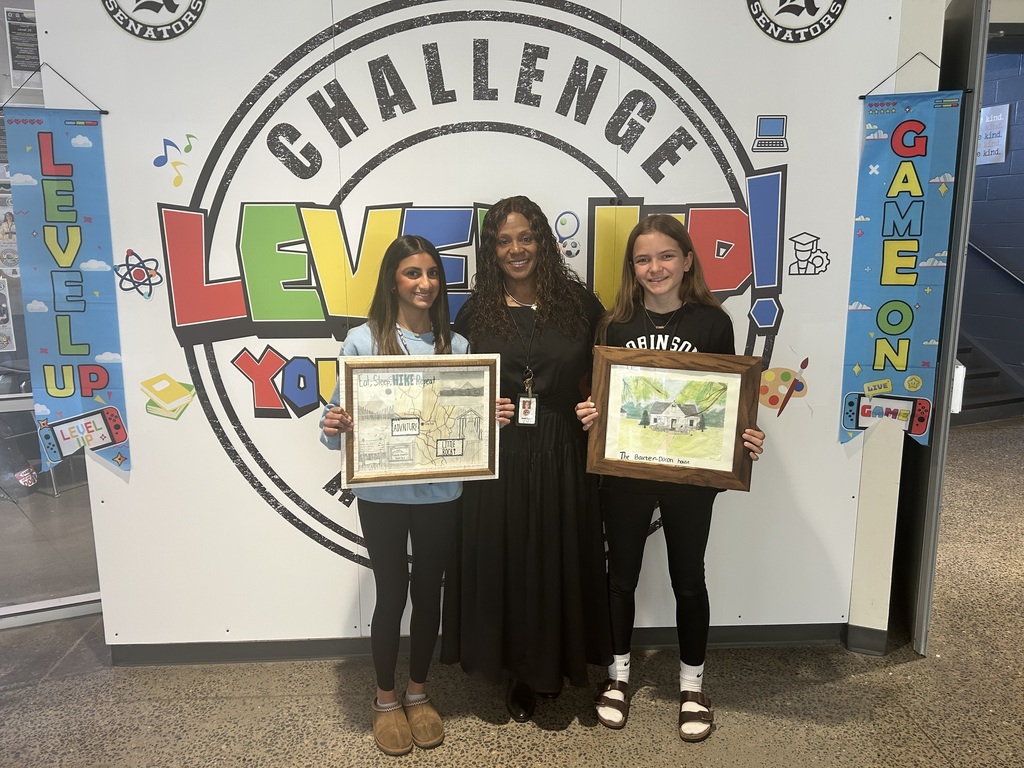 Two young women holding award certificates stand in front of a colorful "Challenge Level Up" backdrop.