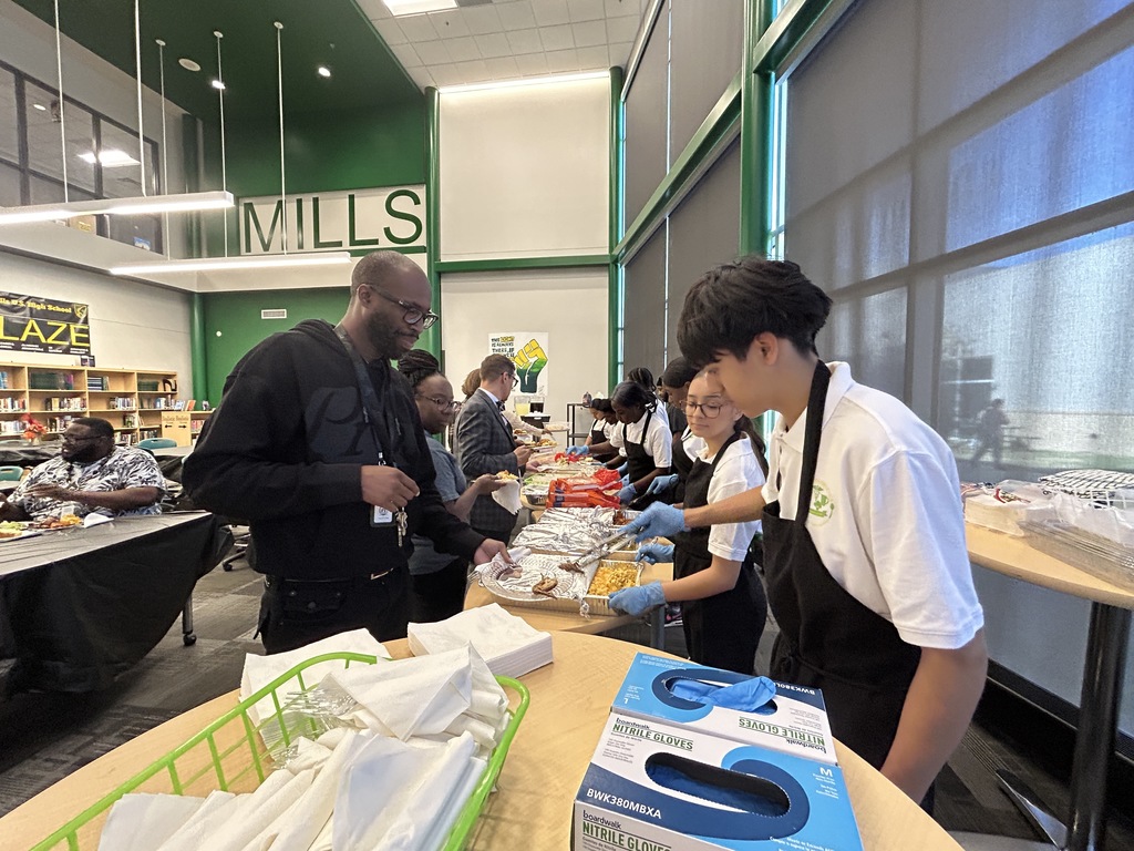 Students serving food to adults