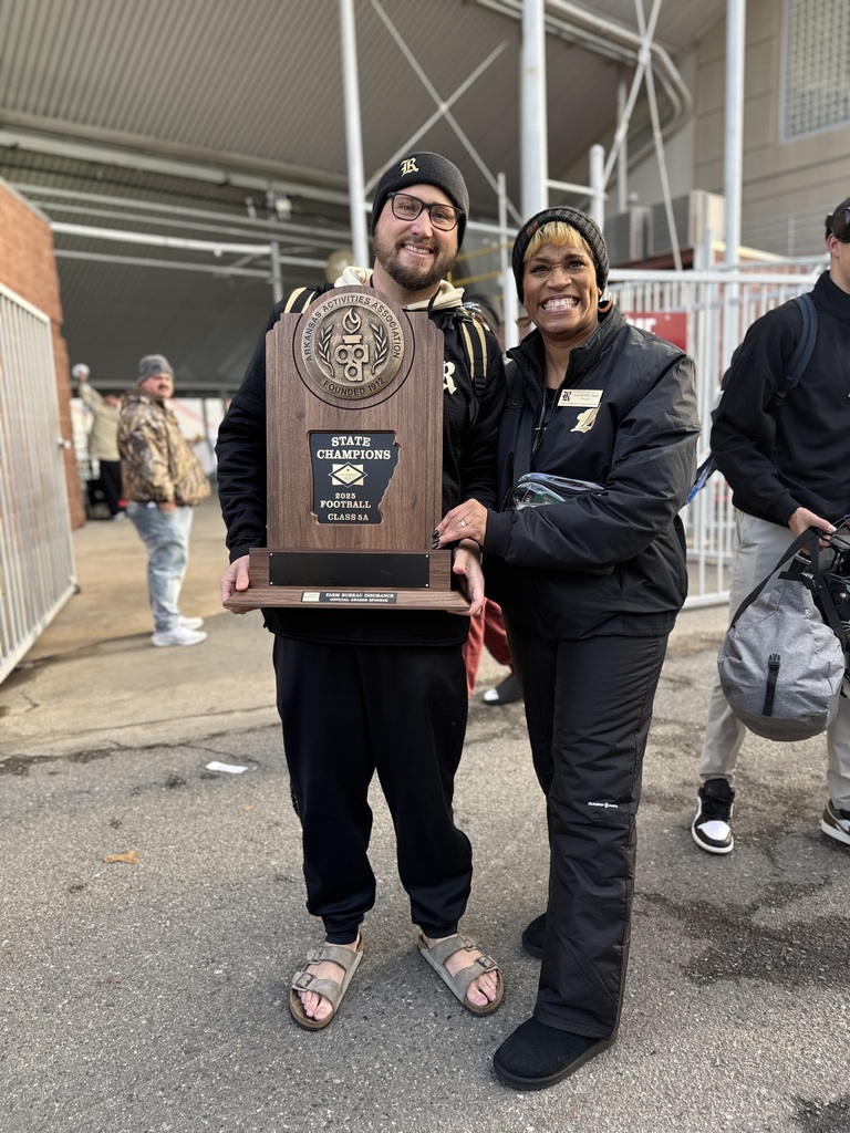 Head Coach Tyler Uptergrove and Principal Laconya Isaac holding the AAA Class 5A State Championship Trophy! 