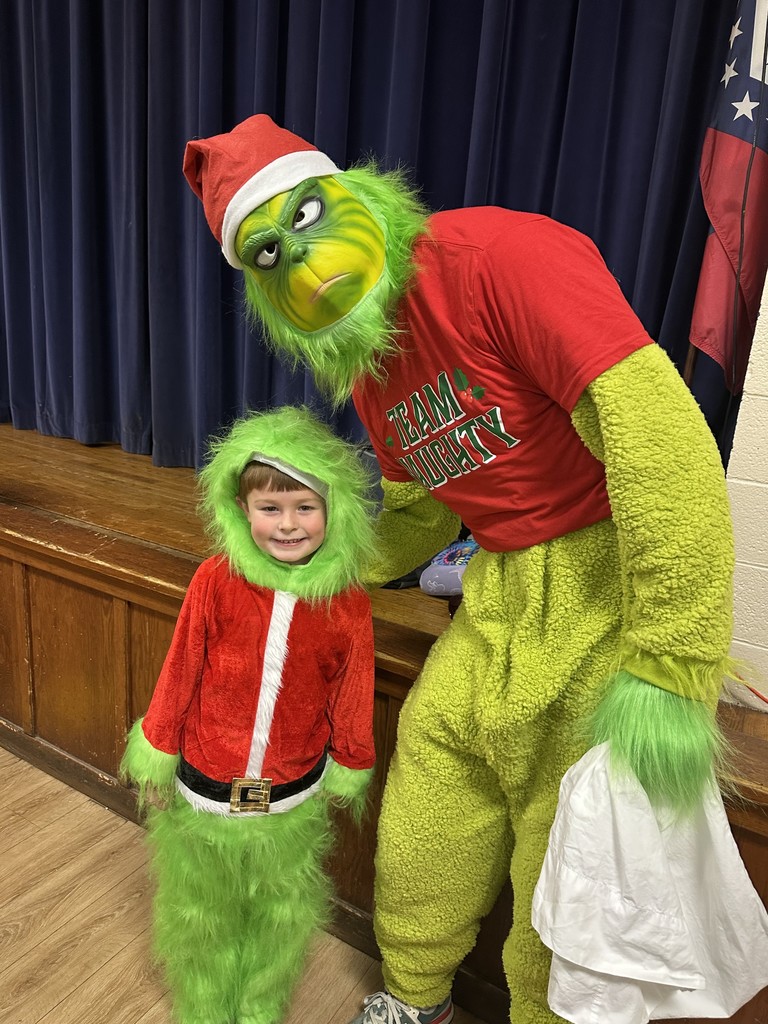 Image of the Grinch with a kindergarten student who is also dressed as the grinch