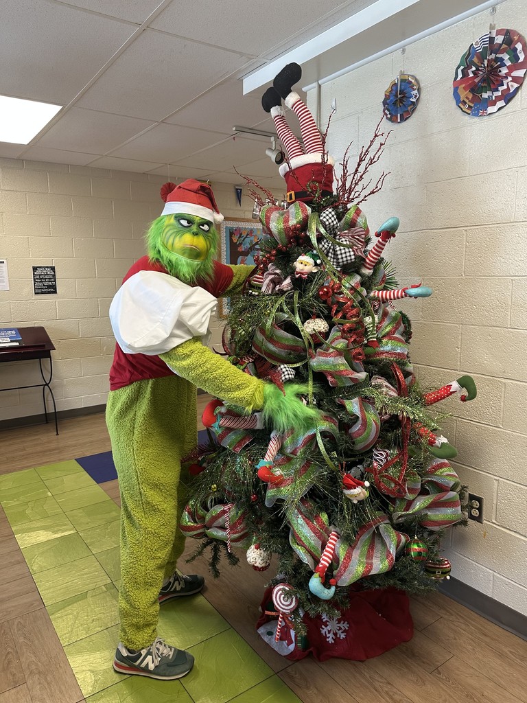 Image of the grinch standing next to our Lawson Christmas Tree