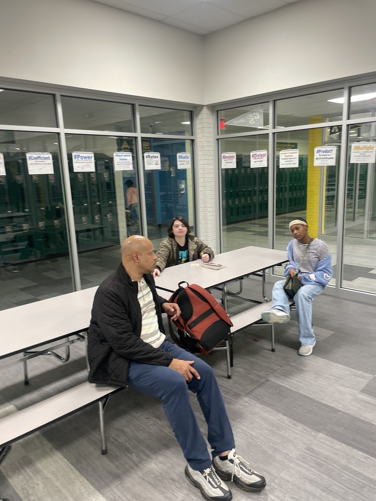 1 man in cafeteria with two students.