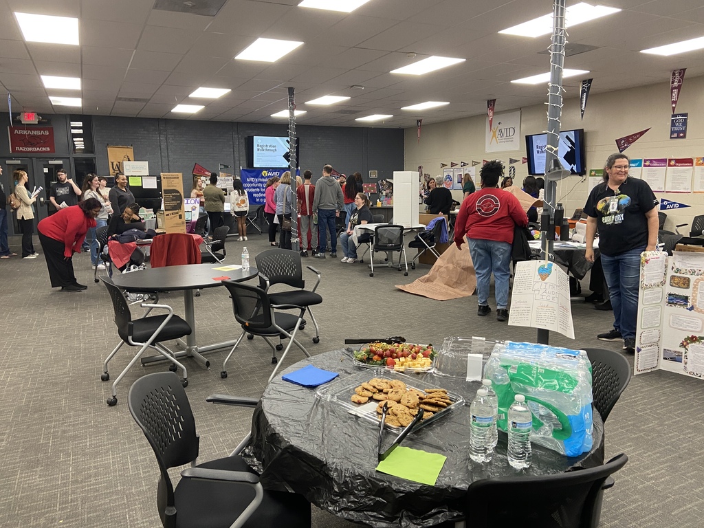 A room full of people with tables, chairs, refreshments. They are holding the Senator Showcase for students.