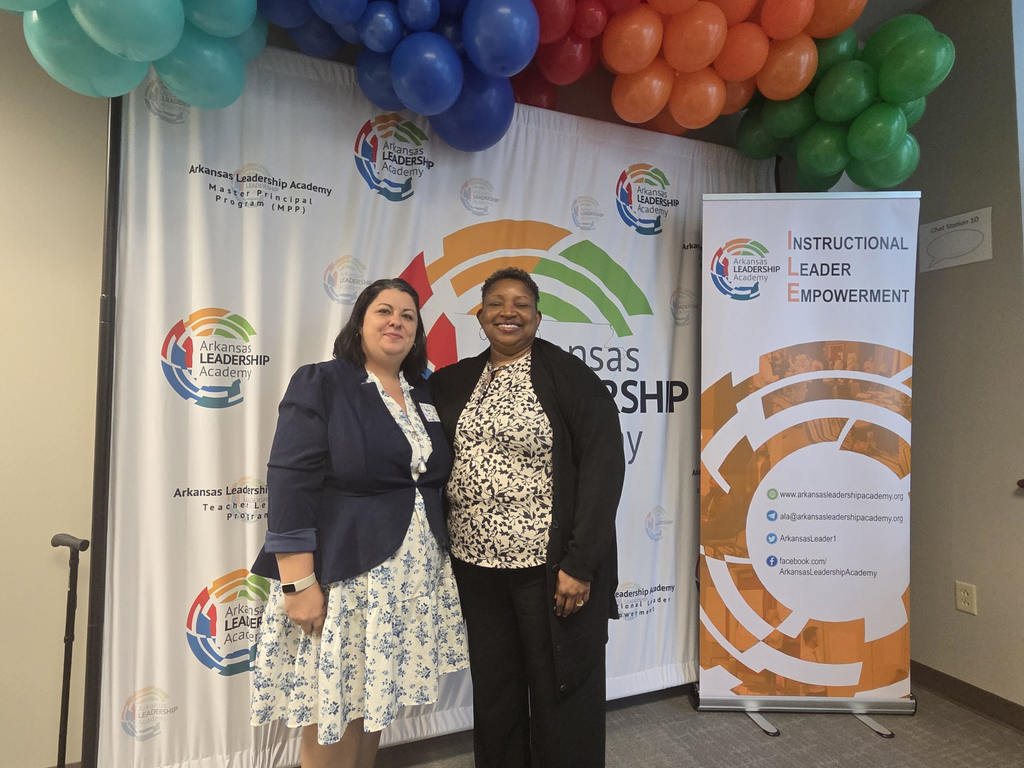 Ciara Cole and Katrina Jones standing in front of balloons and a banner for the Arkansas Leadership Academy Instructional Leader Empowerment Program