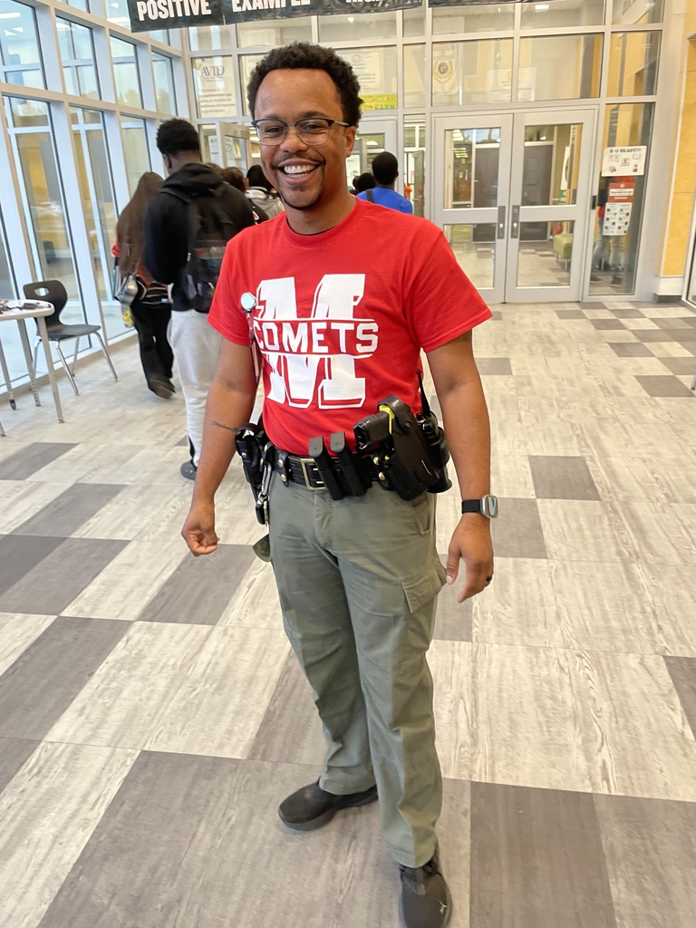 A man with a red shirt on is smiling. 