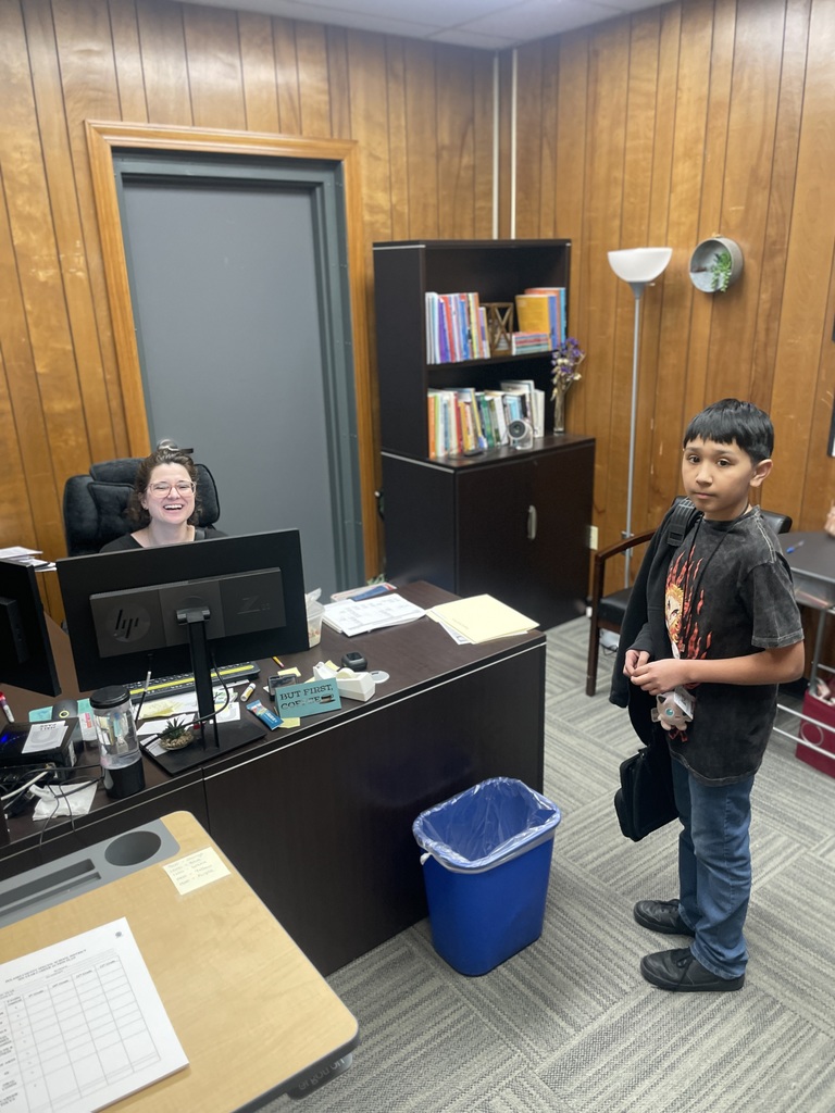 Woman sitting at desk and smiling. 