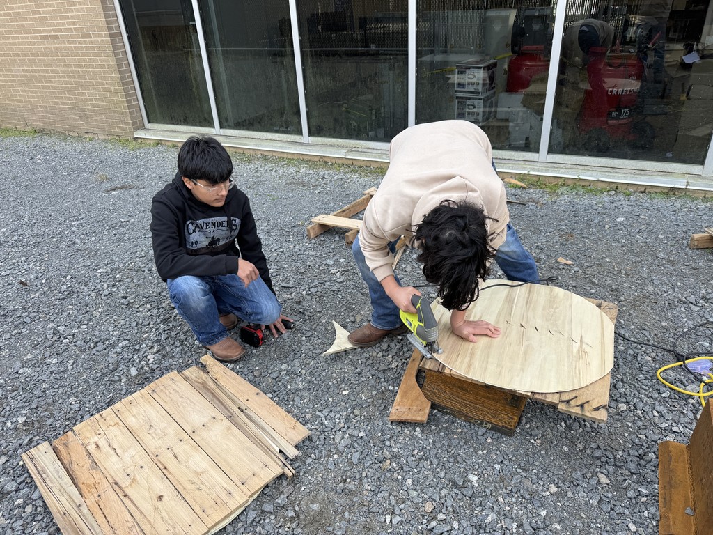 Welding students using skill saw outside.