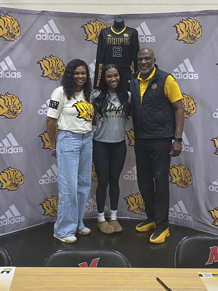 Three people standing side by side. The woman in the middle is wearing a UAPB Volleyball shirt.