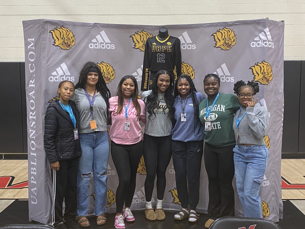 Seven girls smiling at a camera side by side.
