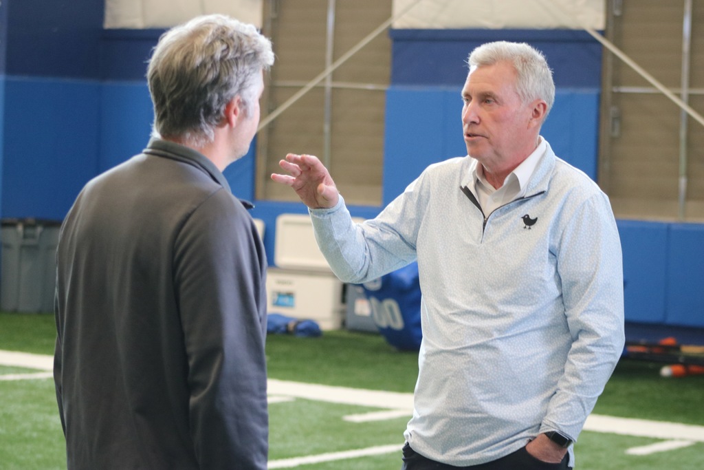Two men in grey hair talking to each other in an interview style