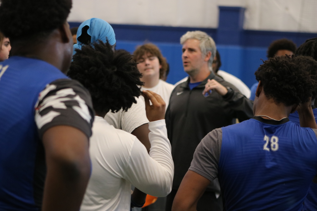 Football players in a huddle listening to their head coach