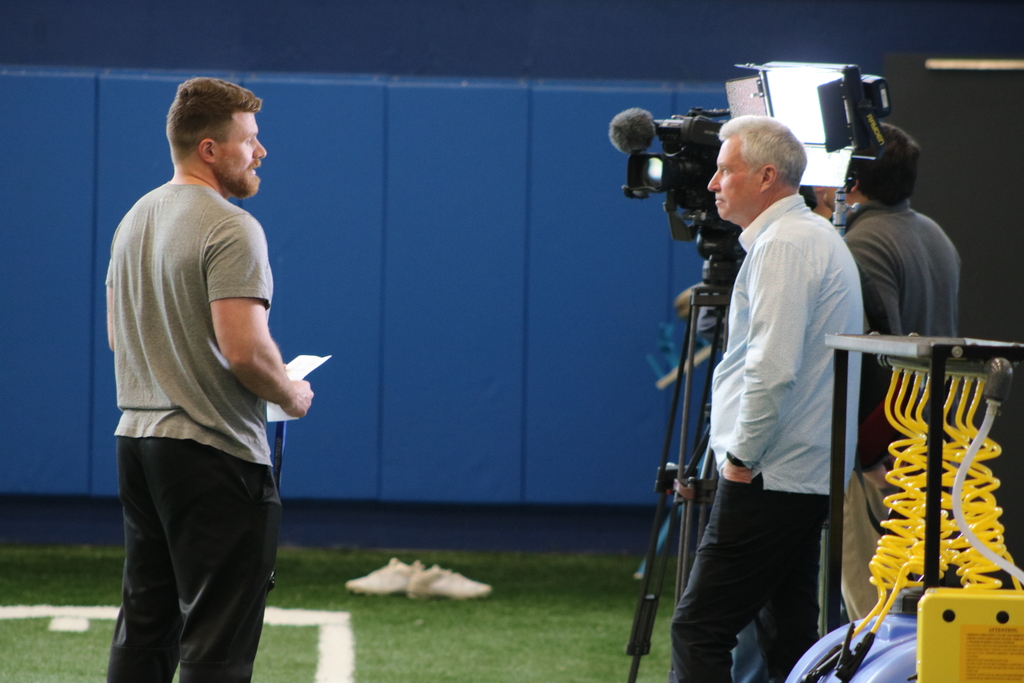 A football coach giving a tv interview