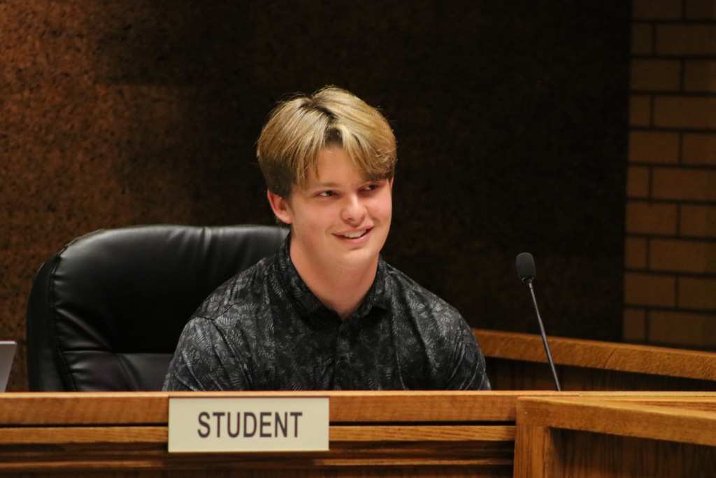Student board member smiling in his chair