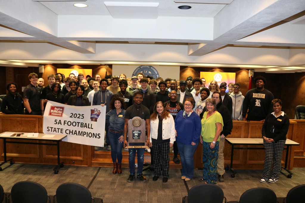 a team photo of the Joe T. Robinson State champs in a board room