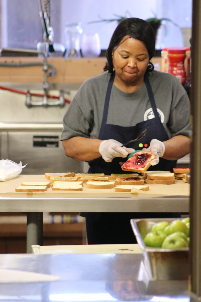 A cafeteria worker at Lawson Elementary preparing food