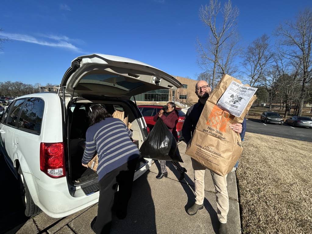 People loading a mini-van with items
