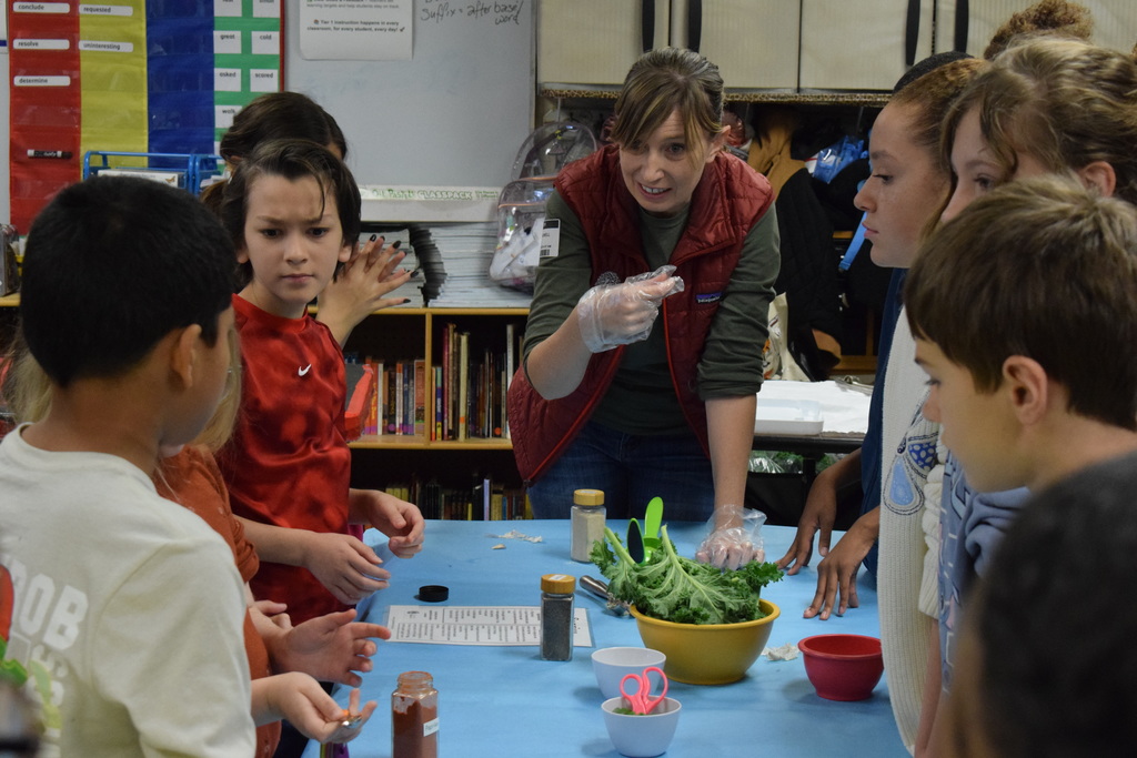 An Apple Seeds worker engaging with students at a table