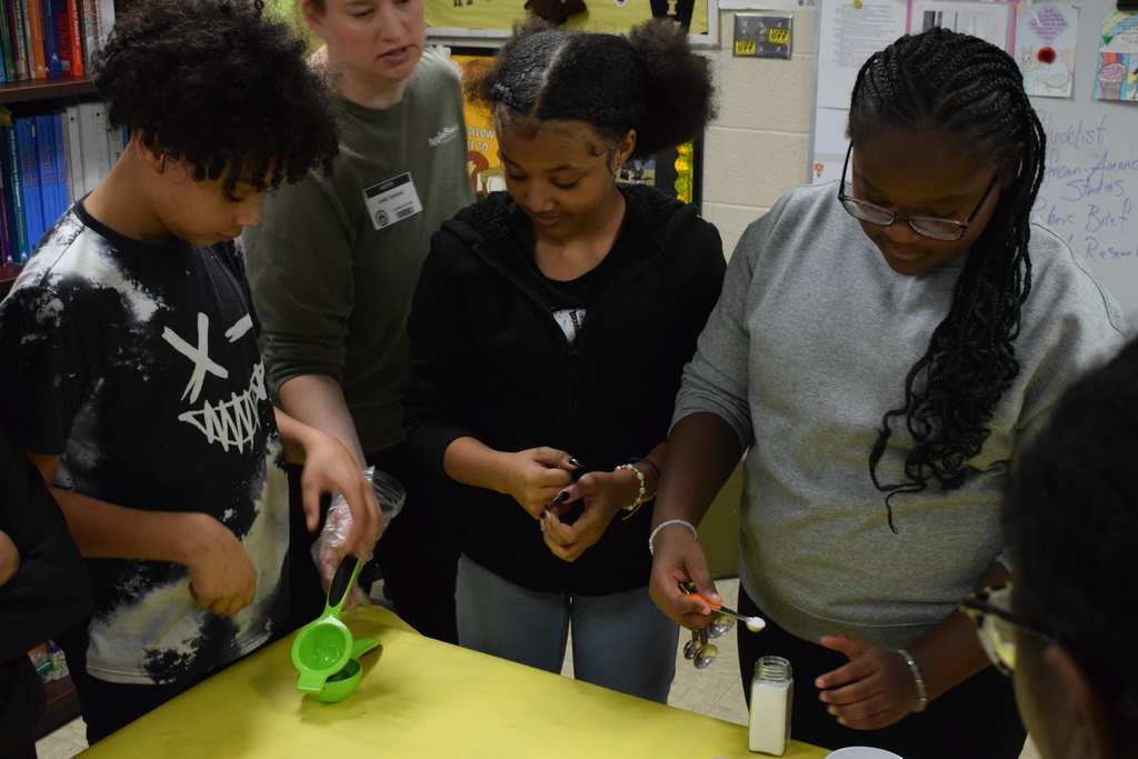 Students measuring out salt and using a lemon squeezer
