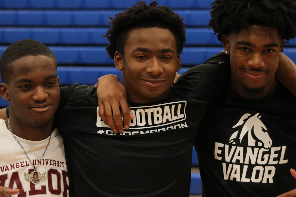 The teammates stand beside each other smiling