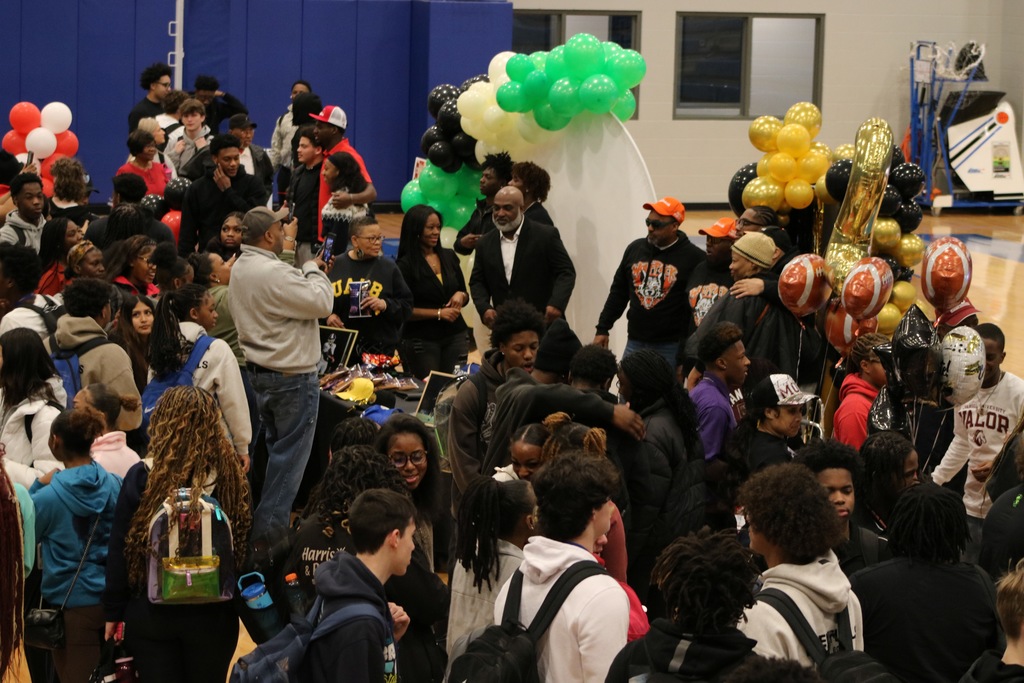 A crowd picture of people celebrating after a college signing event.