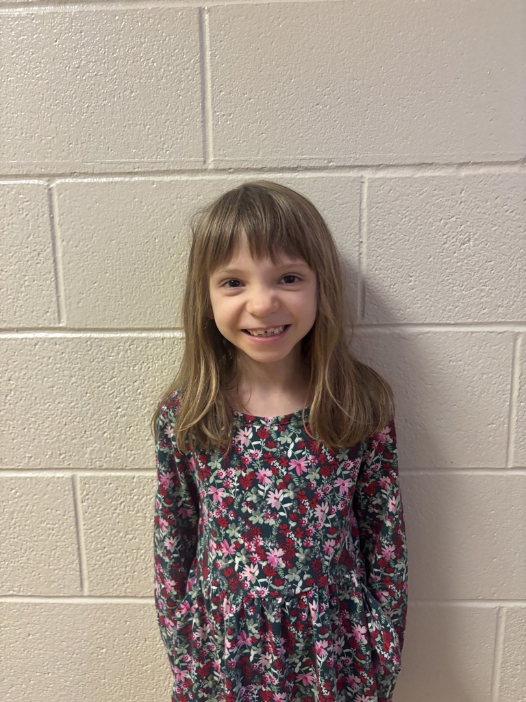 First Grade student who was nominated for Student of the Month. She is in a floral dress. 