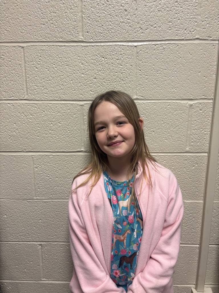 Fourth Grade student who was nominated for Student of the Month. She is in a blue horse and floral print shirt with a pink jacket. 
