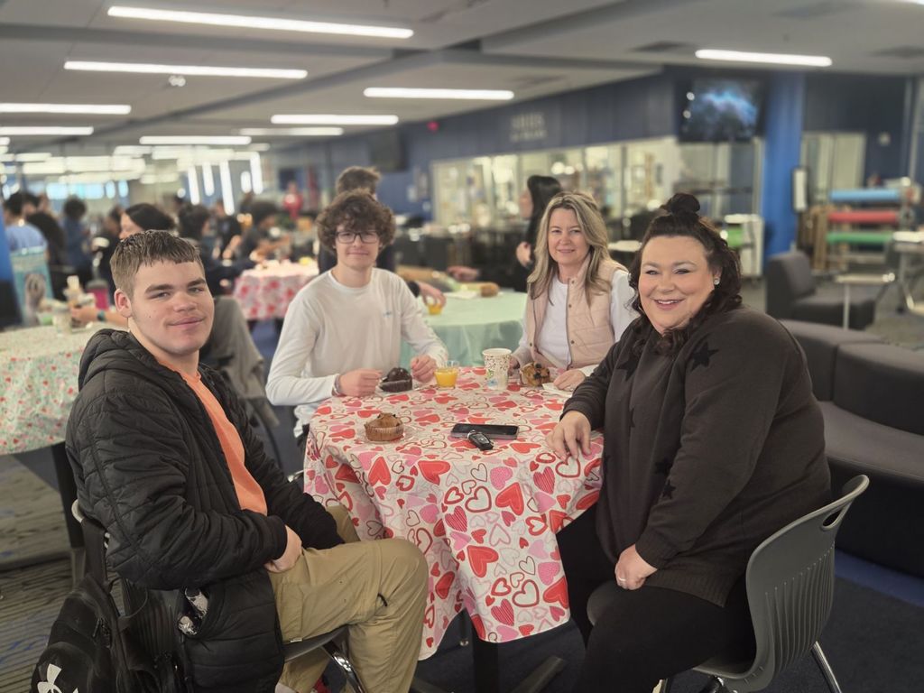 A group picture of mothers and sons smiling together