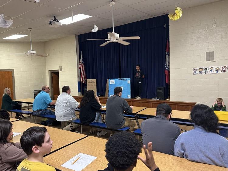 Image of a fifth grade student presenting, his invention was “The Back Saver". A device used to help garden.