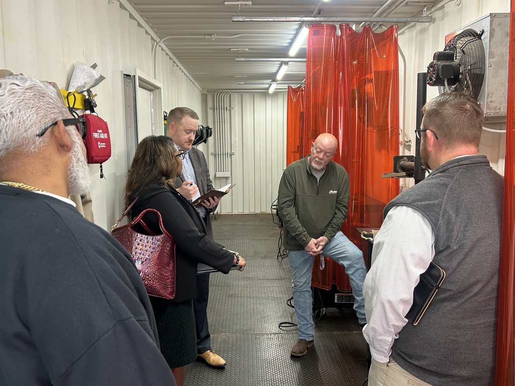 Adults walking through the welding training site